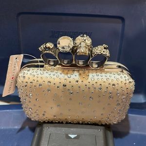 Brand new light gold colored, clutch with brass knuckle handle